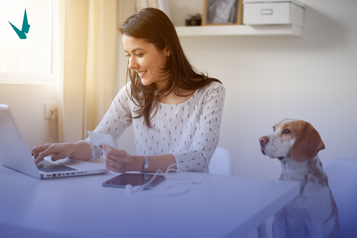 Woman Working from home on her computer with her dog.